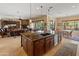 Spacious open kitchen boasts dark wood cabinets, granite countertops, and seamless flow to living and dining areas at 31705 N 128Th Dr, Peoria, AZ 85383