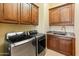 Convenient laundry room with modern washer/dryer, ample cabinets, and granite counter sink at 31705 N 128Th Dr, Peoria, AZ 85383