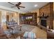 Cozy living room with stone fireplace, custom built-ins, and comfortable seating at 31705 N 128Th Dr, Peoria, AZ 85383
