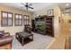 Cozy living room with custom built-in shelving, leather furniture, ceiling fan and window shutters at 31705 N 128Th Dr, Peoria, AZ 85383