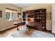 Home office with custom built-ins, a wood desk, and a window overlooking the landscaped yard at 31705 N 128Th Dr, Peoria, AZ 85383