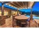 Covered outdoor kitchen and dining area with a built-in grill and comfortable seating by the pool at 31705 N 128Th Dr, Peoria, AZ 85383