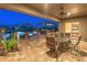 Covered patio with an outdoor dining setup and views of the pool and built-in outdoor kitchen, perfect for entertaining at 31705 N 128Th Dr, Peoria, AZ 85383
