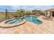 Inviting backyard pool and spa with outdoor kitchen, lounge chairs, and desert landscaping offers the perfect retreat at 31705 N 128Th Dr, Peoria, AZ 85383