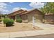 Beige home showing a two-car garage and a desert-style yard in a residential neighborhood at 3248 W Sunshine Butte Dr, San Tan Valley, AZ 85144