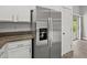 Stainless steel refrigerator with water dispenser, granite countertops, and white cabinets near outdoor access at 3248 W Sunshine Butte Dr, San Tan Valley, AZ 85144