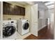 Laundry room with wood floors, dark cabinetry, and stainless steel washer and dryer at 33 W Missouri Ave # 17, Phoenix, AZ 85013