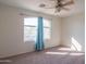 Carpeted bedroom featuring a ceiling fan and window with blue curtains at 3365 N Sunaire --, Mesa, AZ 85215