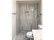 Bathroom featuring an updated shower with unique tile and pebble flooring at 3556 W Augusta Ave, Phoenix, AZ 85051