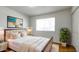 This staged bedroom boasts a plush bed, accent wall art, and a window for natural light at 3556 W Augusta Ave, Phoenix, AZ 85051