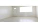 Empty room with light tile flooring and large windows letting in sunlight at 3556 W Augusta Ave, Phoenix, AZ 85051