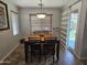 Cozy dining area featuring a wooden table with chairs, complemented by a modern light fixture, perfect for Gathering meals at 36119 W Catalan St, Maricopa, AZ 85138
