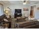 Inviting living room with plush couches, a ceiling fan, and a large TV, perfect for relaxation and entertainment at 36119 W Catalan St, Maricopa, AZ 85138