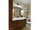 Bathroom vanity with dark wood cabinets, cream countertop, decorative mirror and tile backsplash at 3811 E Evans Dr, Phoenix, AZ 85032
