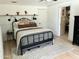 Bright bedroom with a wrought iron bed frame, a decorative board and batten wall, and an ensuite bathroom at 3811 E Evans Dr, Phoenix, AZ 85032