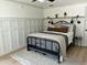 Bright bedroom with a wrought iron bed frame, a decorative board and batten wall, and a light-colored rug at 3811 E Evans Dr, Phoenix, AZ 85032