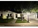 Inviting single-story home at night with landscape lighting illuminating the well-kept lawn and front entrance at 3811 E Evans Dr, Phoenix, AZ 85032