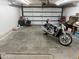 View of a garage featuring a motorcycle, storage boxes, and a white paneled garage door at 3811 E Evans Dr, Phoenix, AZ 85032