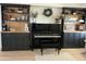 Living room showcasing a decorative piano with custom built-in bookshelves and decor at 3811 E Evans Dr, Phoenix, AZ 85032