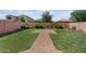Expansive backyard with lush green grass, brick-paved pathway, and privacy fence at 3936 E Narrowleaf Dr, Gilbert, AZ 85298