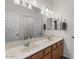 Bathroom featuring double sinks, wood cabinets, and a large mirror at 3936 E Narrowleaf Dr, Gilbert, AZ 85298