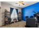 Bright bedroom with blue accent wall, shelving, and window with light-filtering blinds at 3936 E Narrowleaf Dr, Gilbert, AZ 85298