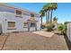 White two-story home showcasing a gravel backyard and mature palm trees under a bright blue sky at 5345 E Mclellan Rd # 123, Mesa, AZ 85205