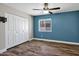 Bedroom features a blue accent wall, wood floors, a ceiling fan, and a closet at 5345 E Mclellan Rd # 123, Mesa, AZ 85205