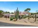 Inviting desert home with a well-manicured yard, mature cacti, palm trees, and lush green landscaping at 5345 E Mclellan Rd # 123, Mesa, AZ 85205