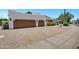 Spacious two-car garage with an extended driveway and desert landscaping in a residential neighborhood at 5345 E Mclellan Rd # 123, Mesa, AZ 85205