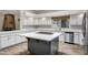 A bright kitchen featuring white cabinets, a center island, and wood-look flooring at 5345 E Mclellan Rd # 123, Mesa, AZ 85205