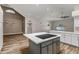 Kitchen with a central island, cooktop, white cabinets, and open floor plan into the living room at 5345 E Mclellan Rd # 123, Mesa, AZ 85205