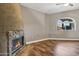 Cozy living room with a stone fireplace, wood floors, and a bright arched window at 5345 E Mclellan Rd # 123, Mesa, AZ 85205