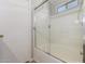 Well-lit bathroom showing bathtub with sliding glass door with shower head at 5675 S 239Th Ln, Buckeye, AZ 85326