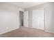Neutral bedroom featuring carpet, ceiling fan, closet, and entry to an adjacent room at 5675 S 239Th Ln, Buckeye, AZ 85326