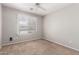 Bedroom features a ceiling fan, wall to wall carpet, and a large window at 5675 S 239Th Ln, Buckeye, AZ 85326