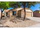 Charming single-story house with desert landscaping, mature trees, and a cozy feel at 5675 S 239Th Ln, Buckeye, AZ 85326