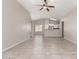 Open living room with tile flooring and ceiling fan, flowing into kitchen at 5675 S 239Th Ln, Buckeye, AZ 85326