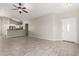 Bright living room with tile floors, ceiling fan, and view to front door at 5675 S 239Th Ln, Buckeye, AZ 85326