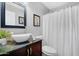 Updated bathroom with a stylish vessel sink, dark wood cabinets, and white shower curtain at 5711 E Gable Ave, Mesa, AZ 85206