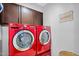 Bright laundry room features red washer and dryer with dark cabinets at 5711 E Gable Ave, Mesa, AZ 85206