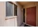 Exterior entrance with a neutral painted surface, decorative lantern, window and a solid red door at 602 E Colgate Dr, Tempe, AZ 85283