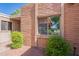 Exterior home detail showing red brick, neutral trim and a double window surrounded by leafy green bushes at 602 E Colgate Dr, Tempe, AZ 85283