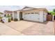 Spacious driveway leading to a white two-car garage with a charming brick paver accent at 605 W Sandra Terrace Ter, Phoenix, AZ 85023