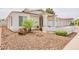 Well-manicured front yard with decorative rock landscaping, shrubs, and palm tree at 605 W Sandra Terrace Ter, Phoenix, AZ 85023