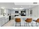 Bright kitchen with gray cabinets, black appliances, a breakfast bar with seating and quartz countertops at 605 W Sandra Terrace Ter, Phoenix, AZ 85023
