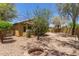 Cozy backyard with gravel, mature trees and bushes, and a brick fire pit at 7003 S 23Rd Ln, Phoenix, AZ 85041