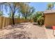 Spacious backyard features gravel landscaping, a brick fire pit, and a secure perimeter fence at 7003 S 23Rd Ln, Phoenix, AZ 85041