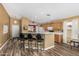 Bright kitchen with a breakfast bar, wood cabinets and views into the dining and living areas at 7003 S 23Rd Ln, Phoenix, AZ 85041