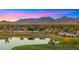 Stunning aerial view of the community with a lake and golf course against a mountain backdrop at sunset at 7424 N Via Camello Del Norte -- # 185, Scottsdale, AZ 85258